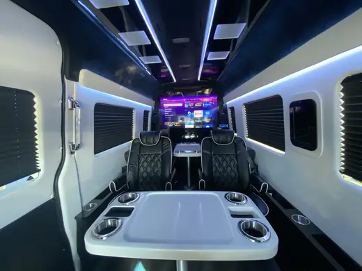 Jet Sprinter cabin table and seats beneath blue lighting — Point-to-Point Sprinter Van Transfers